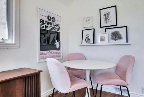 a dining room with a white table and pink chairs at The Gem - Beautiful farmhouse with hot tub in West Lake