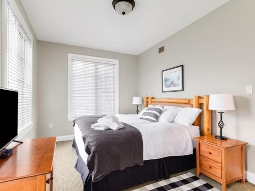 a bedroom with a bed and a desk and a tv at All Season Ski in out Chalet at Calabogie Peaks in Calabogie