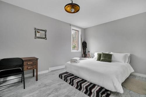 a white bedroom with a bed and a desk at La Hacienda - Edelweiss après-ski - wooded escape in Val des Monts