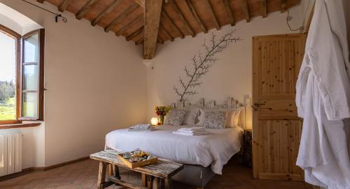 a bedroom with a white bed and a table at Ca'Novae - Tuscany Farmhouse in Montieri