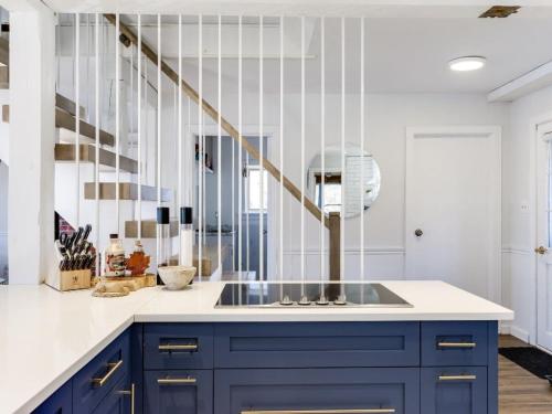 una cocina con armarios azules y una escalera en Cozy family waterfront retreat recently renovated, en Deseronto