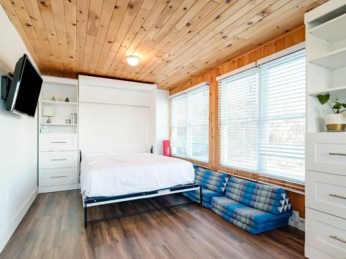 1 dormitorio con 1 cama y 1 sofá en Cozy family waterfront retreat recently renovated, en Deseronto