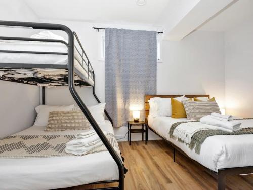 een slaapkamer met 2 stapelbedden en een raam bij The Eyrie: Sweeping views waterfront sunlit escape in Val des Monts