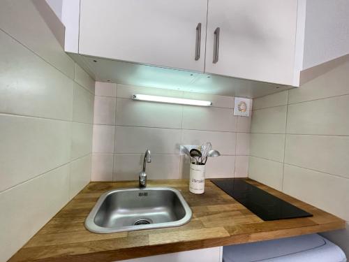 un bancone della cucina con lavello e armadietti bianchi di Mestral Apto en planta baja con piscina ad Arenal d'en Castell