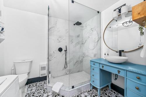 y baño con ducha, armario azul y lavamanos. en The Birch Suite at Portage House in Picton, en Picton