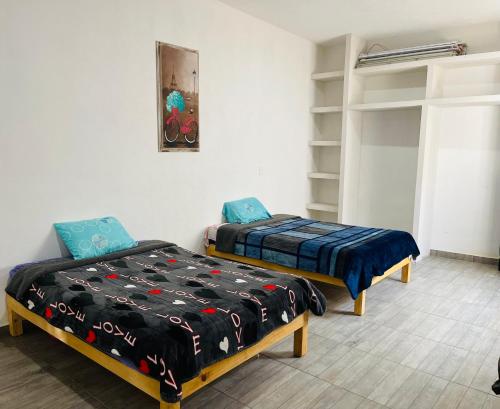 een kamer met 2 bedden en een plank bij Quinta Tequis San José in La Laja