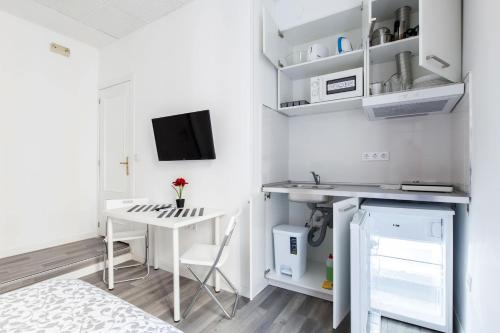 a small white room with a desk and a bed at Gilbert accommodations in London