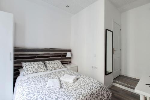 a white bedroom with a large bed with two pillows at Gilbert accommodations in London