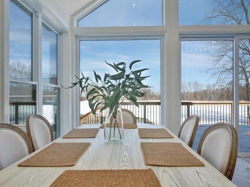 ein Esszimmer mit einem Tisch und einer Vase aus Blumen in der Unterkunft Gorgeous private retreat with hot tub in White Lake