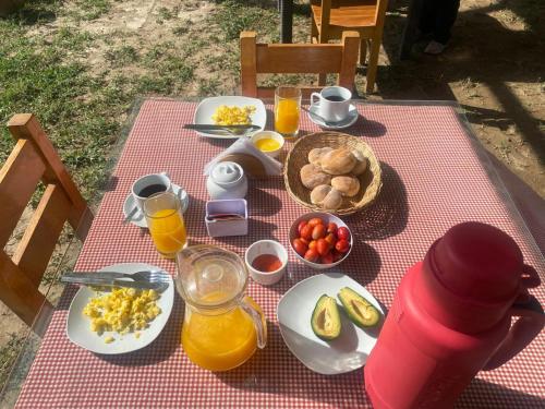 a picnic table with plates of food and orange juice at HOTEL HACIENDA SUBTANJALLA CASABLANCA in El Cambio