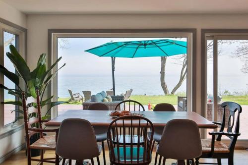 a dining room with a table and chairs and an umbrella at Lakeside PEC: Beautiful Waterfront & Patio in Wellington