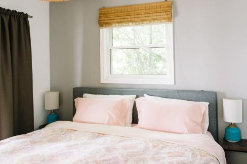 a bedroom with a bed with white pillows and a window at Lakeside PEC: Beautiful Waterfront & Patio in Wellington