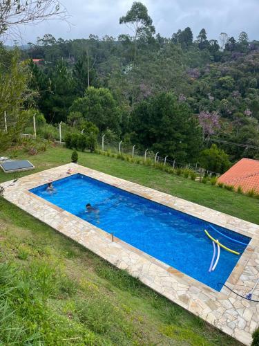 - une piscine dans une cour avec 2 personnes dans l'établissement Casa Uno chácara, à Suzano