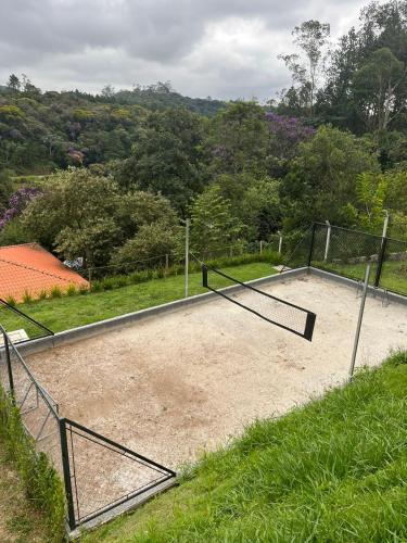 un court de tennis au milieu d'un champ dans l'établissement Casa Uno chácara, à Suzano