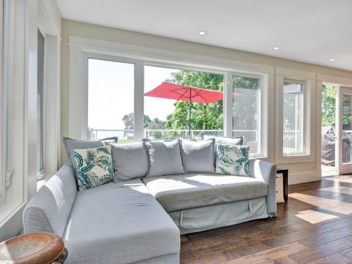 a living room with a couch and a red umbrella at Wind & Waves - Wellington waterfront with Satellite TV & fire pit in Wellington