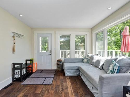 a living room with a couch and windows at Wind & Waves - Wellington waterfront with Satellite TV & fire pit in Wellington