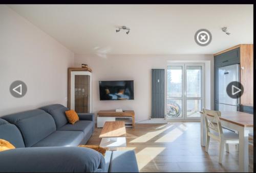 ein Wohnzimmer mit einem blauen Sofa und einem Tisch in der Unterkunft Blue Sky Apartment in Gdynia