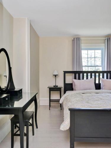 a bedroom with a bed with a mirror and a desk at Wind & Waves - Wellington waterfront with Satellite TV & fire pit in Wellington