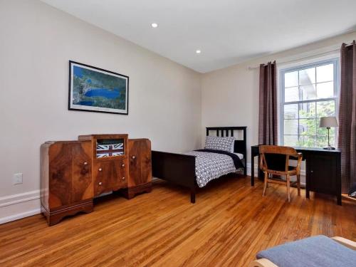 a bedroom with a bed and a dresser and a desk at Wind & Waves - Wellington waterfront with Satellite TV & fire pit in Wellington