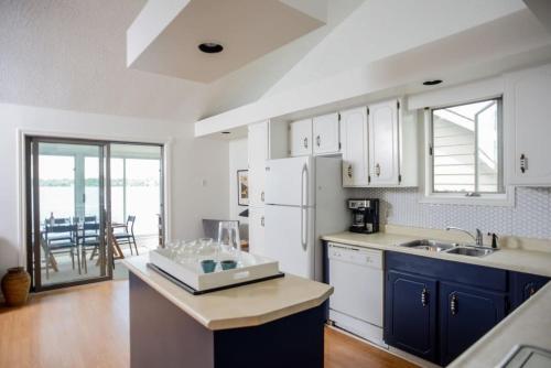a kitchen with blue cabinets and a white refrigerator at The Verne: Beautiful Waterfront Escape by Picton in Picton