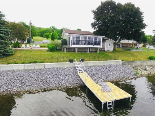 a house with a pelican sitting on a dock in the water at The Verne: Beautiful Waterfront Escape by Picton in Picton