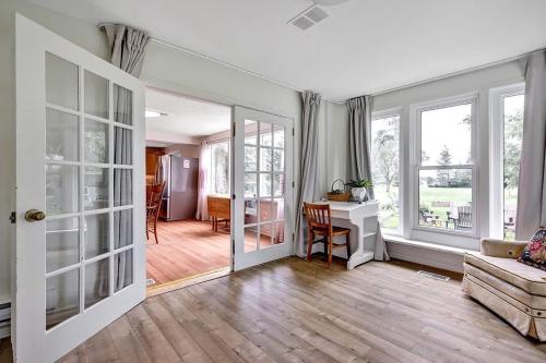 a living room with a couch and a desk and windows at The Highway House - PEC Waterview Getaway in Wellington