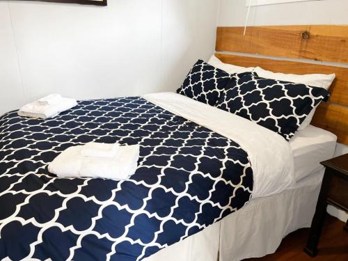 - un lit avec une couette et des oreillers bleus et blancs dans l'établissement The Cherry Valley: Couple's Romantic PEC Getaway, à Wellington