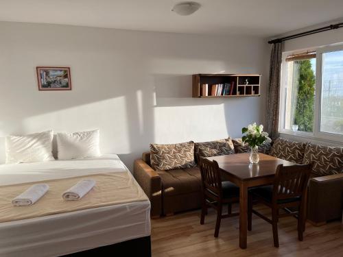 a room with two beds and a table and a couch at Квартира студия на берегу моря in Byala