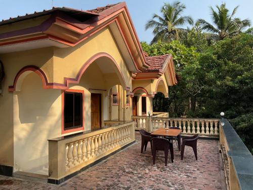 a house with a table and chairs on a patio at Grace Homestay in Benaulim