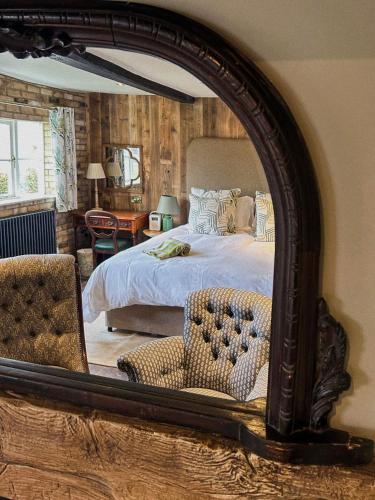 a bedroom with a bed and a large mirror at The Fitzherbert Farmhouse in Swynnerton