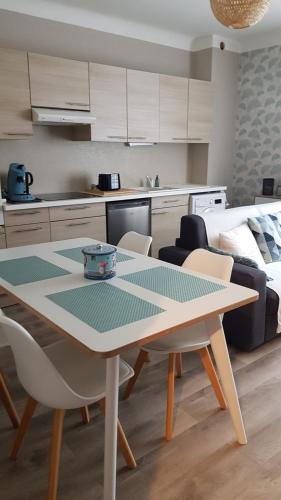 une cuisine et une salle à manger avec une table et des chaises dans l'établissement Cœur de Falaise, Normandie Suisse Normande, à Falaise