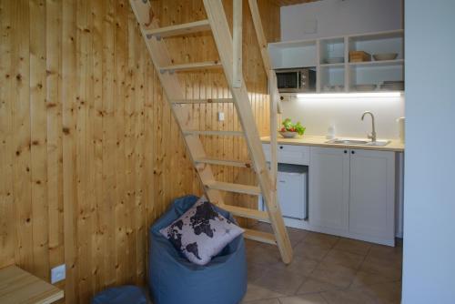 eine Holztreppe in einer Küche mit einer Theke in der Unterkunft Domek Rewa in Rewa