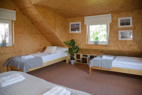 a attic room with two beds and two windows at Domek Rewa in Rewa