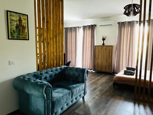 Una sala de estar con un sofá azul y una mesa. en Apartament Studio BiAn, en Timisoara