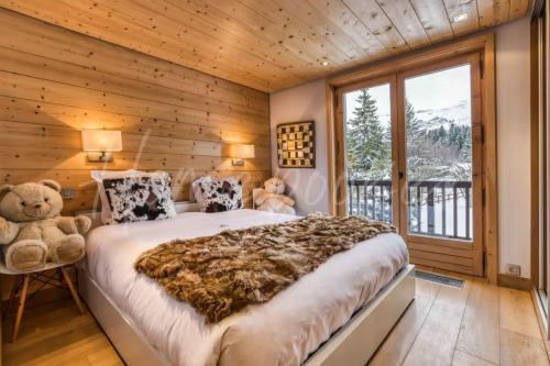 - une chambre avec un grand lit et deux ours en peluche dans l'établissement Yupik, à Megève