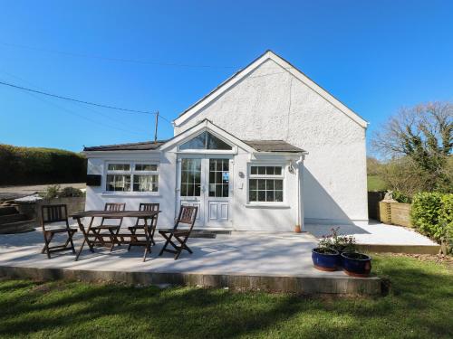 a white house with a table and chairs at Little Bobbins in Saundersfoot