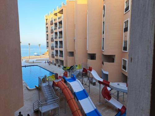 Juliana Beach Hurghada في الغردقة: زحليقة مائية أمام مبنى به مسبح