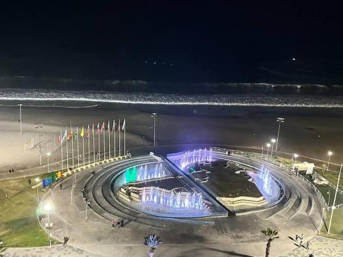 a building with lights on the beach at night at Paraíso frente al mar en Iquique in Iquique