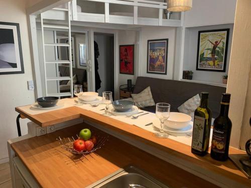 - une cuisine avec une table, un bol de fruits et des bouteilles de vin dans l'établissement A092-Studio agreable avec mezzanine - Le Suquet, à Cannes