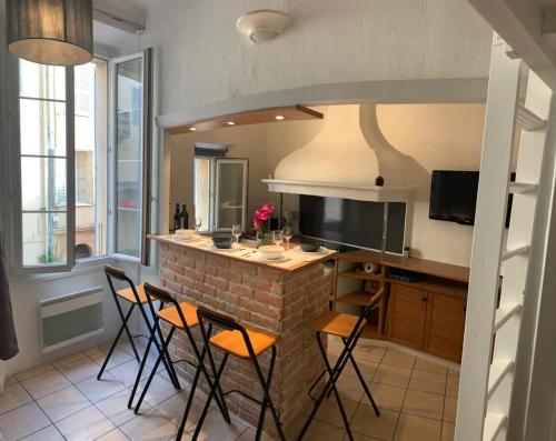 Il comprend une cuisine avec un bar et des chaises. dans l'établissement A092-Studio agreable avec mezzanine - Le Suquet, à Cannes