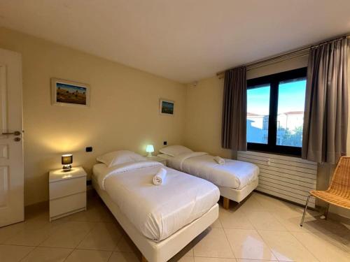une chambre avec deux lits et une grande fenêtre dans l'établissement A003-Magnifique appartement proche du centre de Cannes, à Cannes