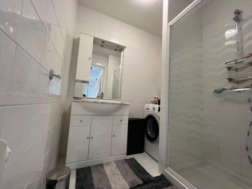 une salle de bain blanche avec un lavabo et une douche dans l'établissement B049-Appartement lumineux à deux pas de la Croisette, à Cannes
