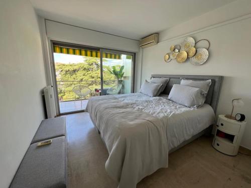 une chambre avec un grand lit avec une grande fenêtre dans l'établissement B049-Appartement lumineux à deux pas de la Croisette, à Cannes