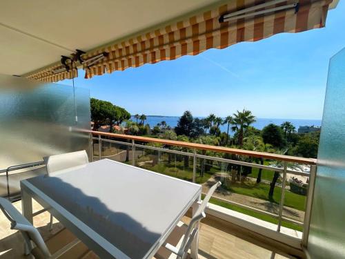 un balcon avec une table et une vue sur l'océan dans l'établissement A085-Splendide appartement refait neuf avec vue mer, à Vallauris