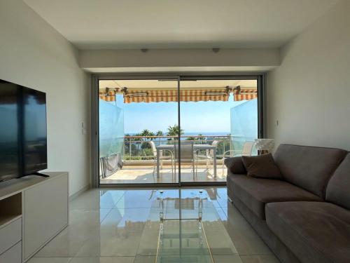 un salon avec un canapé et une vue sur l'océan dans l'établissement A085-Splendide appartement refait neuf avec vue mer, à Vallauris