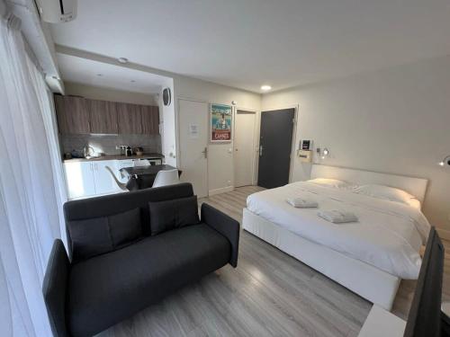 een slaapkamer met een bed en een bank en een keuken bij Beau studio Carré D'Or & Proche de la Mer Cannes in Cannes