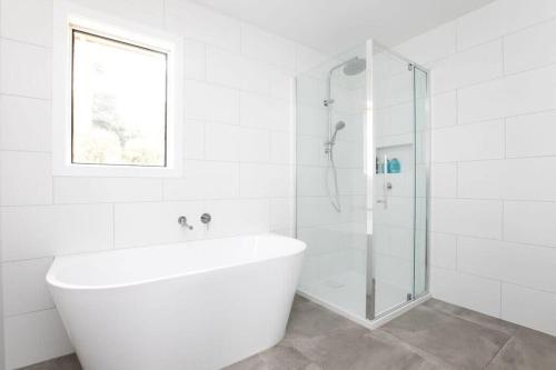 a white bathroom with a tub and a glass shower at Perfect for Families & Groups: Views =& Wi-Fi in Newstead