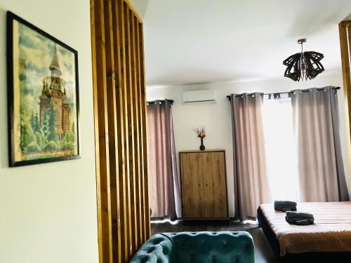 Un dormitorio con una cama y un sofá y una ventana. en Apartament Studio BiAn, en Timisoara