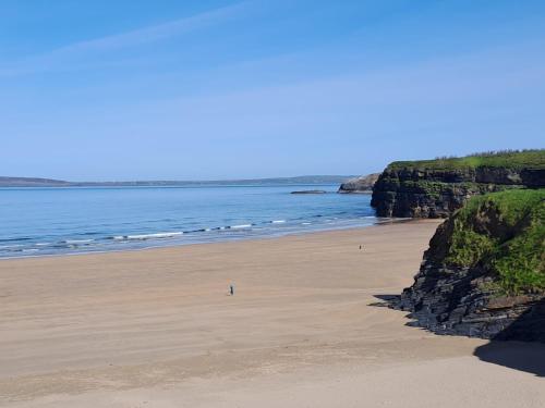 a beach with a person standing on the sand at 18 Ballybunion Holiday Cottages in Ballybunion