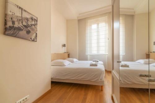 une chambre avec deux lits et un miroir dans l'établissement C096-Apt overlooking the Old Port the view is magical, à Cannes